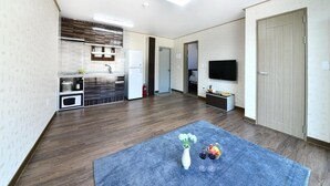 Un appartement moderne doté d’une cuisine, d’un espace de vie et d’un téléviseur.