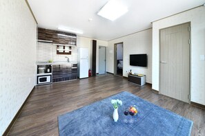 Eine moderne Wohnung mit Küche, Wohnbereich und Fernseher.