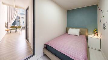 Un dormitorio con una cama, una mesita de noche y una pared decorada con pegatinas.