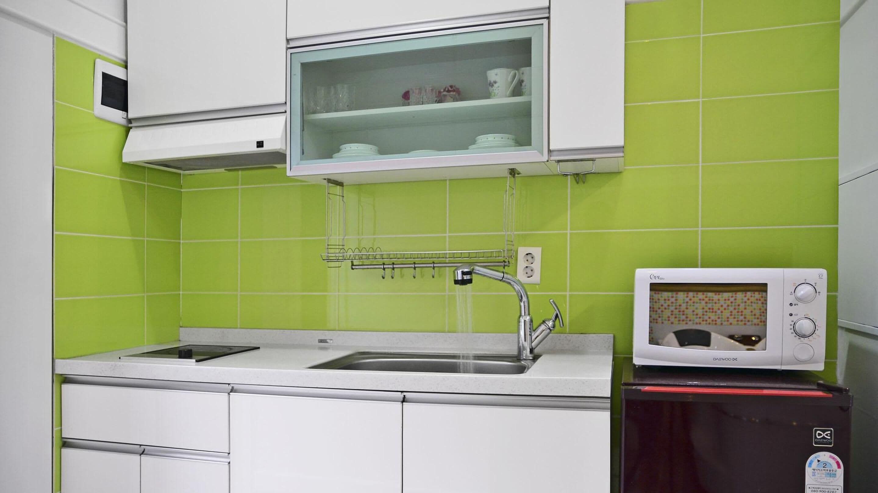 A kitchen with a sink, a microwave, and a cabinet above the sink.