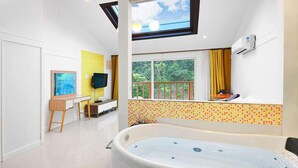 A modern bathroom with a large bathtub, a desk, and a TV. - Gyeongju Green Valley Spa Pension (Gyeongju)
