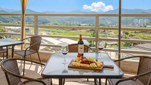 A balcony with a table set for a meal, a bottle of wine, and a glass. - Gapyoeng New Cheongpyeong Pension (Gapyeong)