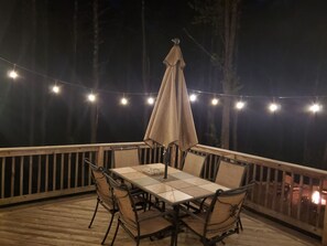 Enjoy al fresco dining on the deck, surrounded by a railing and shaded by an umbrella.