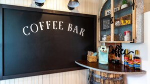 En kaffebar med en skylt som visar texten ”KAFFEBAR”, ett träfat och flaskor med Torani-sirap.