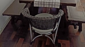 Una mesa de picnic de madera con mantel a cuadros, una cesta tejida y un jarrón decorativo.
