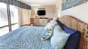 Een slaapkamer met een groot bed, een televisie, een dressoir en een bordje met de tekst 