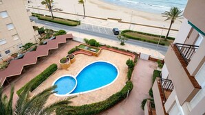 A pool area with a view of the beach and ocean.