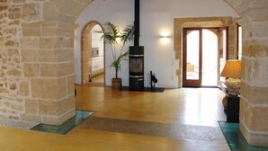 A stone-walled hallway with an arched doorway leading to a kitchen area. - Casa Muralla, Charming Old Town House with Private Pool Alcudia (Alcudia)