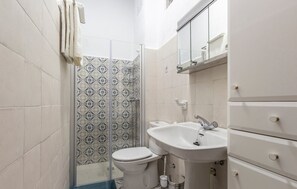A bathroom with a shower, toilet, sink, and a mirror above the sink. - Casa Amelia y Juan de Dios (Padul)