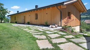 Une maison en bois avec un chemin de pierre menant à l’entrée.
