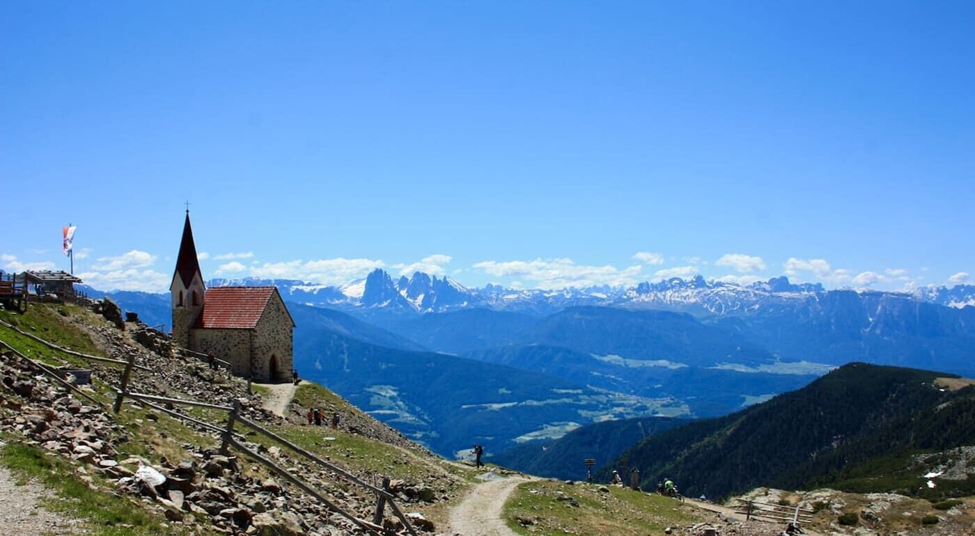 A mountain view with a church and a path leading down.