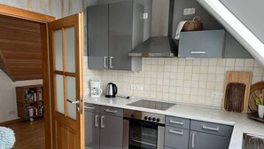 A compact kitchen with grey cabinets, a built-in oven, and a countertop with a coffee maker.