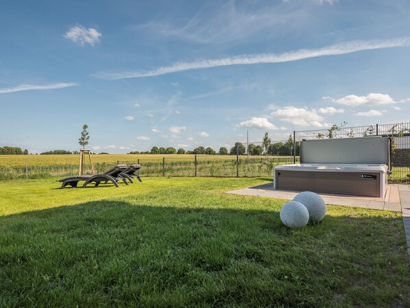 A grassy outdoor area with a modern outdoor seating area and a large water feature.