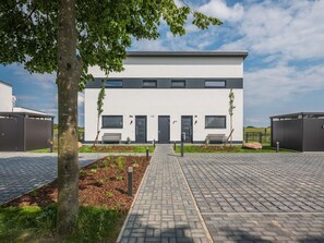 A modern building with a flat roof, two doors, and windows.