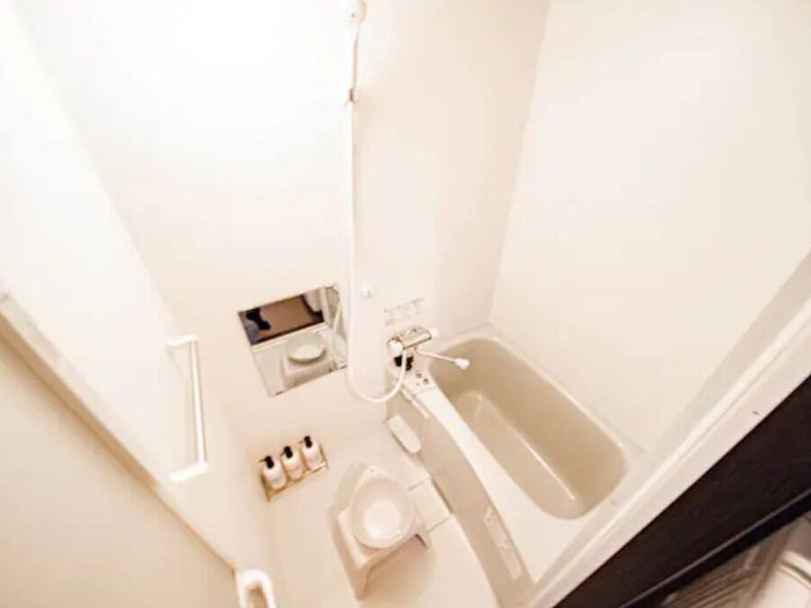 A small, white bathroom with a toilet, bidet, and sink.