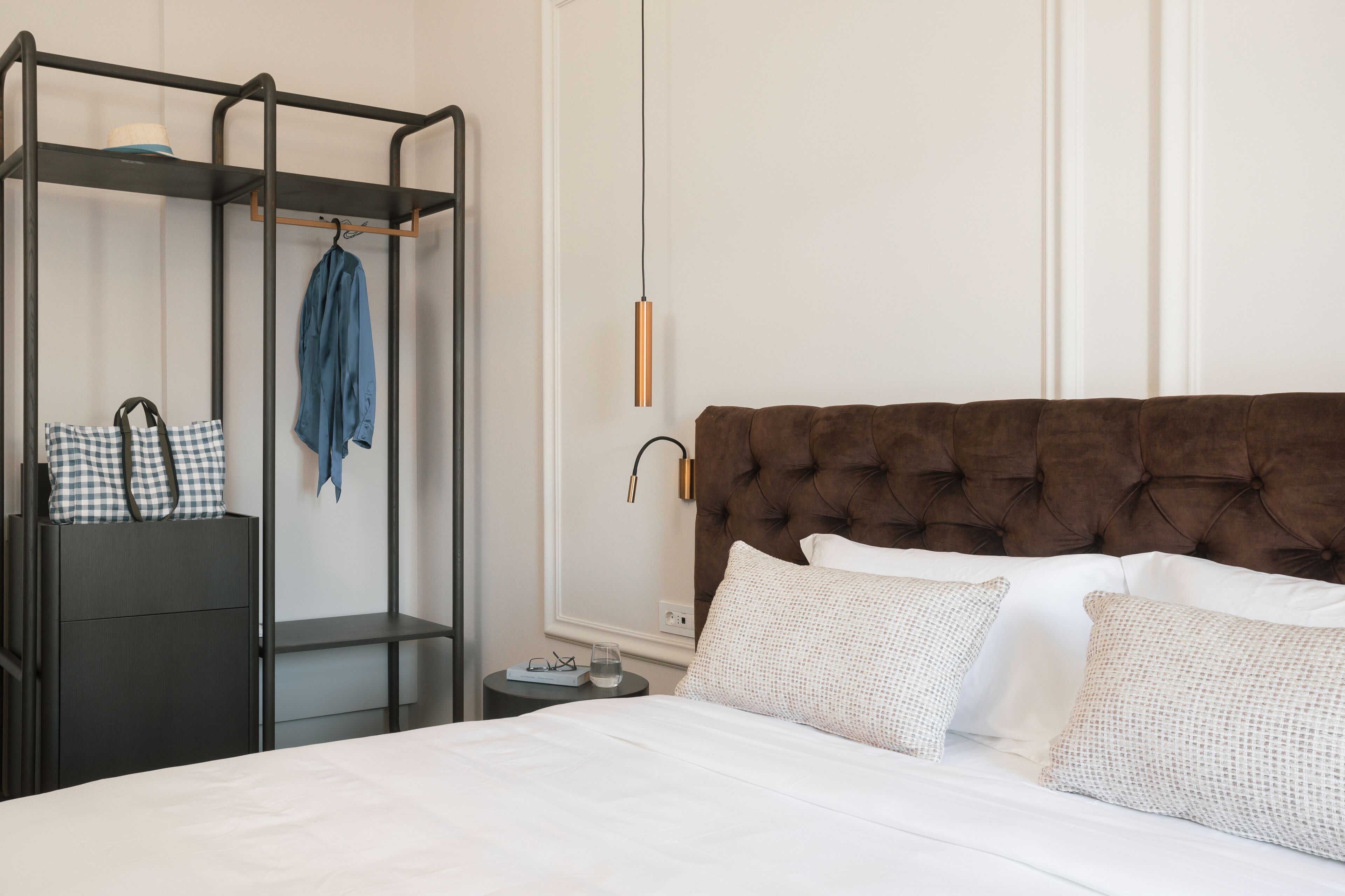 Ein ordentlich eingerichtetes Schlafzimmer mit einem Bett, einem Kleiderschrank und einer Pendelleuchte.