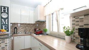 A modern kitchen with white cabinets, a tiled backsplash, a coffee maker, and a potted plant. - House 2087/39057 (Istria - Vinkuran), 500m from the beach (Vinkuran)