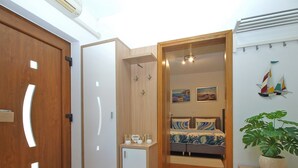 A bedroom with a bed, a small bedside table, a potted plant, and a wall-mounted shelf with decorative items. - House 2087/39057 (Istria - Vinkuran), 500m from the beach (Vinkuran)