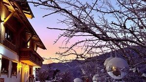 A wooden building with a snow-covered exterior and a staircase leading to the entrance. - ALM SEASONS - Family Chalet-Studio with sauna (Saalbach)