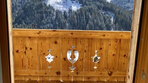 A wooden balcony with a view of a snowy mountain landscape. - ALM SEASONS - Family Chalet-Studio with sauna (Saalbach)