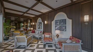 A lobby with a checkered floor, white furniture, and wall-mounted artwork.