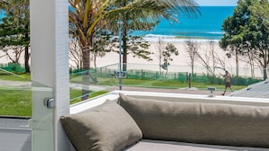 A balcony with a view of the beach and ocean.