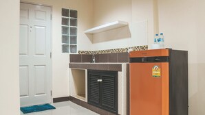 A compact kitchen with a refrigerator, a microwave, and a sink. - Nattida Place (Chiang Mai)