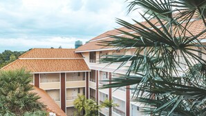 A multi-story building with a red-tiled roof and balconies. - Nattida Place (Chiang Mai)