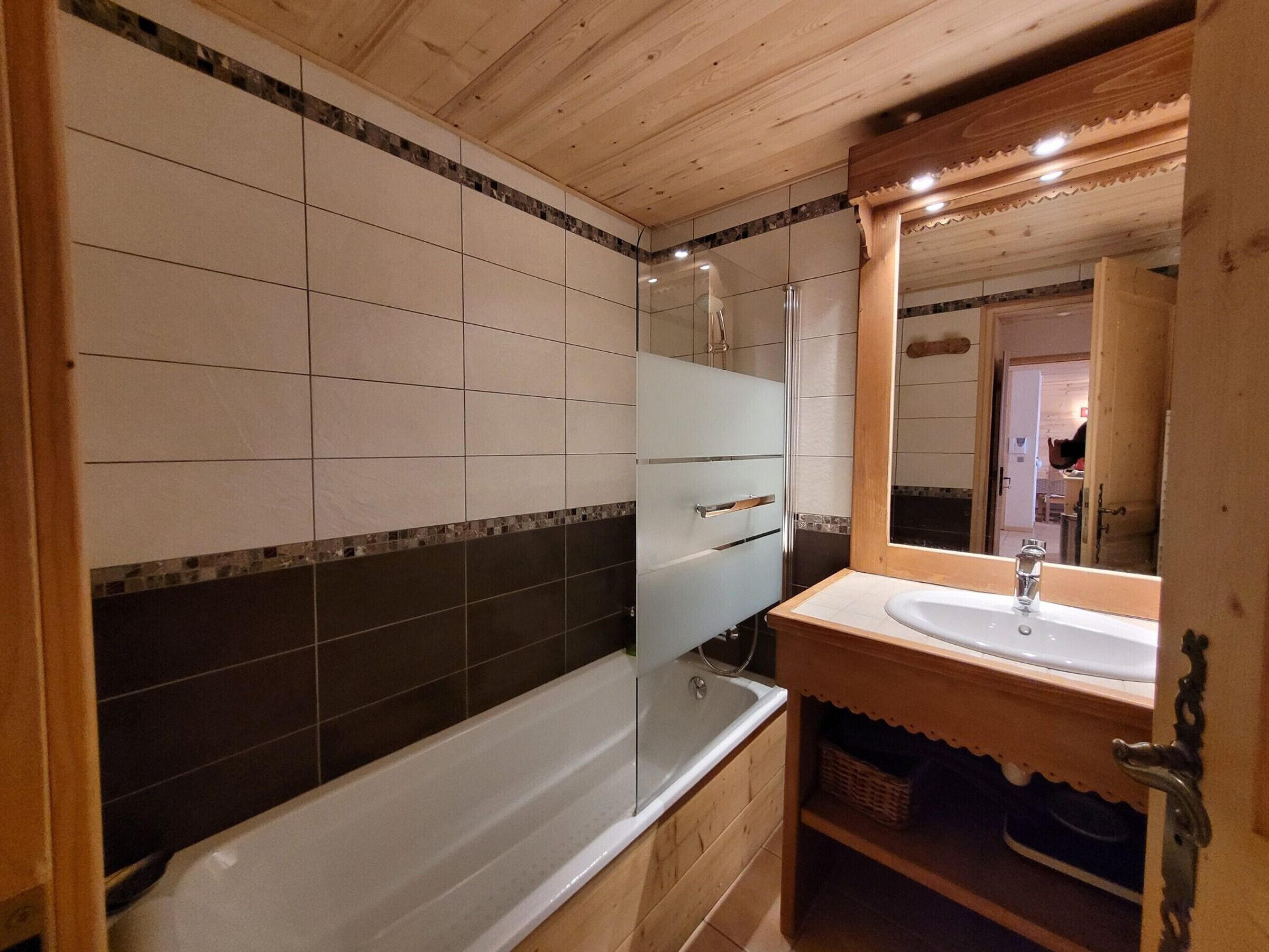 Een badkamer met een bad, een wastafel en een spiegel.