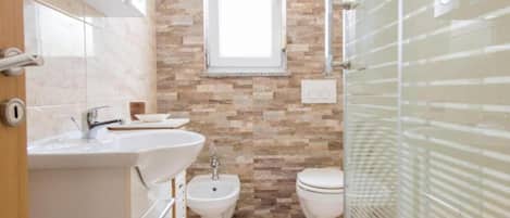 Deluxe appartement | Badkamer | Een douche, een regendouche, een bidet, handdoeken