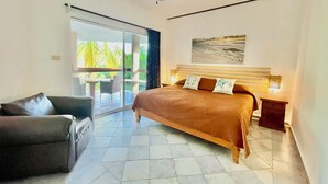 A bedroom with a bed, a chair, a nightstand, and a painting on the wall. - Beautiful 2 Bdrs Villa with Pool,Private Beach,Wi-Fi, Kayaks, Manager, Chef . (Playa del Carmen)