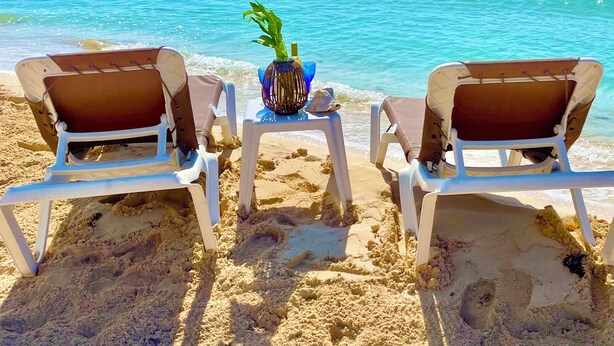 Two beach chairs facing the ocean with a small table between them, a decorative vase, and a seashell. - Beautiful 2 Bdrs Villa with Pool,Private Beach,Wi-Fi, Kayaks, Manager, Chef . (Playa del Carmen)