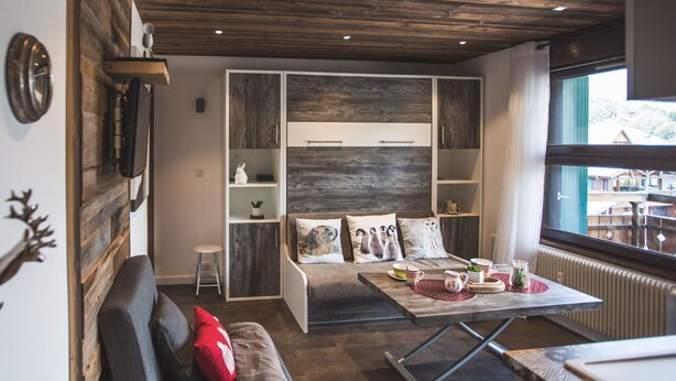 En moderne stue med sofa, sofabord og indbyggede reoler.