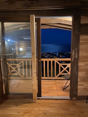 A wooden deck with a view of a city at night.