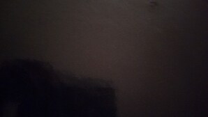 Um quarto escuro com uma sombra visível na parede.