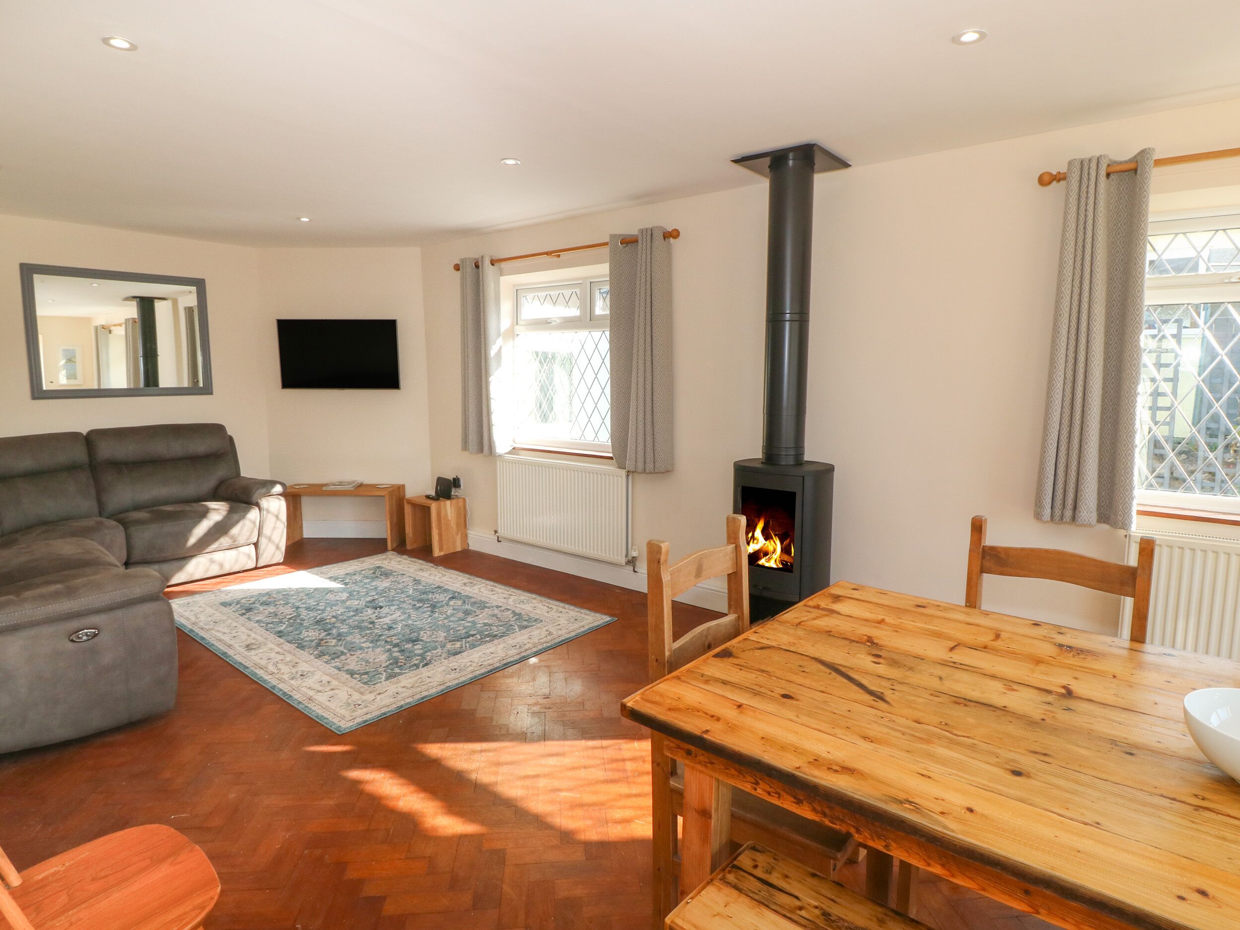 Ein Wohnzimmer mit einer Couch, einem Holztisch, einem Kamin und einem Fernseher.