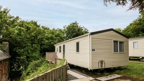 A mobile home with a small porch and a number '80' on the side. - Ochenta (Ilfracombe)