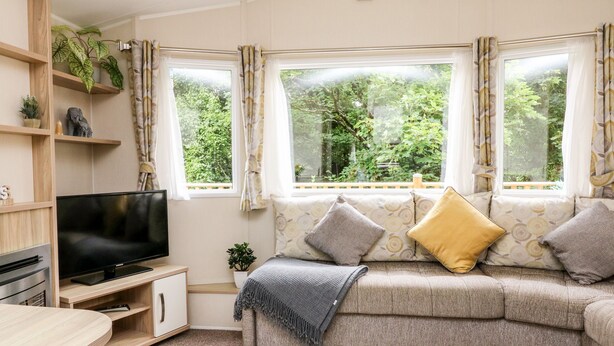 A cozy living room with a sofa, TV, and a small plant. - Ochenta (Ilfracombe)