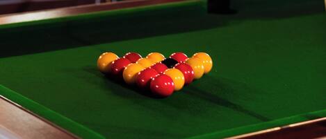 Une table de billard avec les billes disposées en forme de triangle.