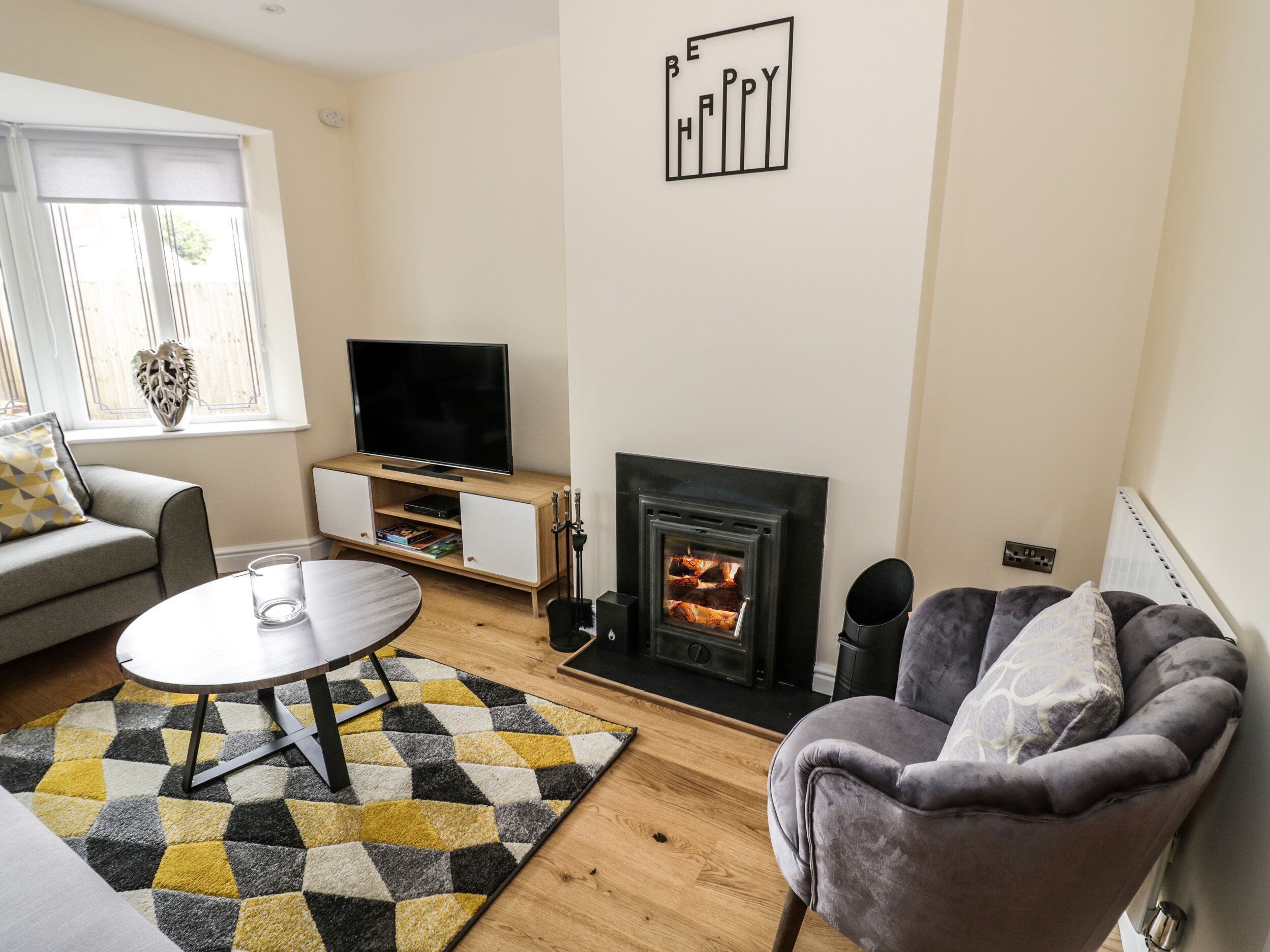 A living room with a television, fireplace, sofa, and a coffee table.