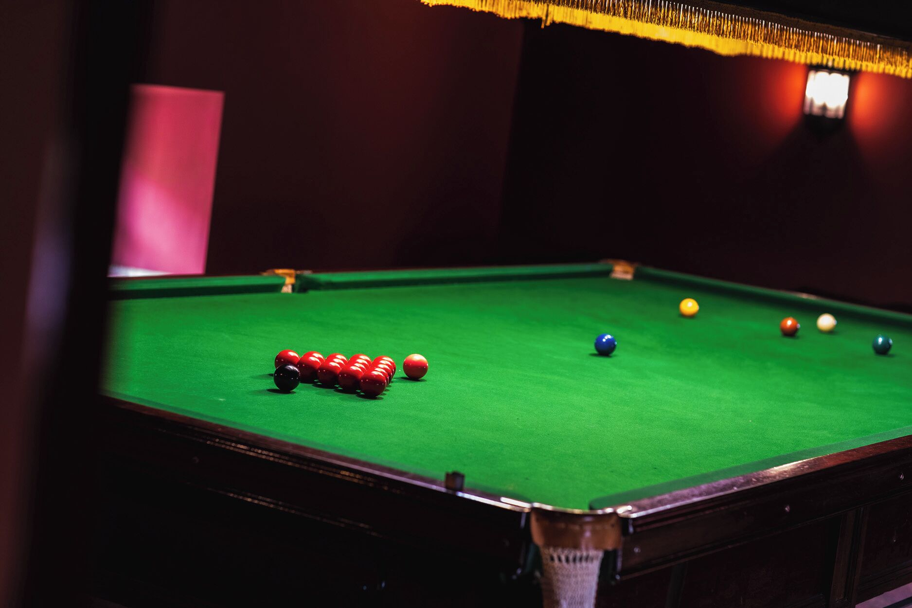 A pool table with balls arranged in a triangle formation.