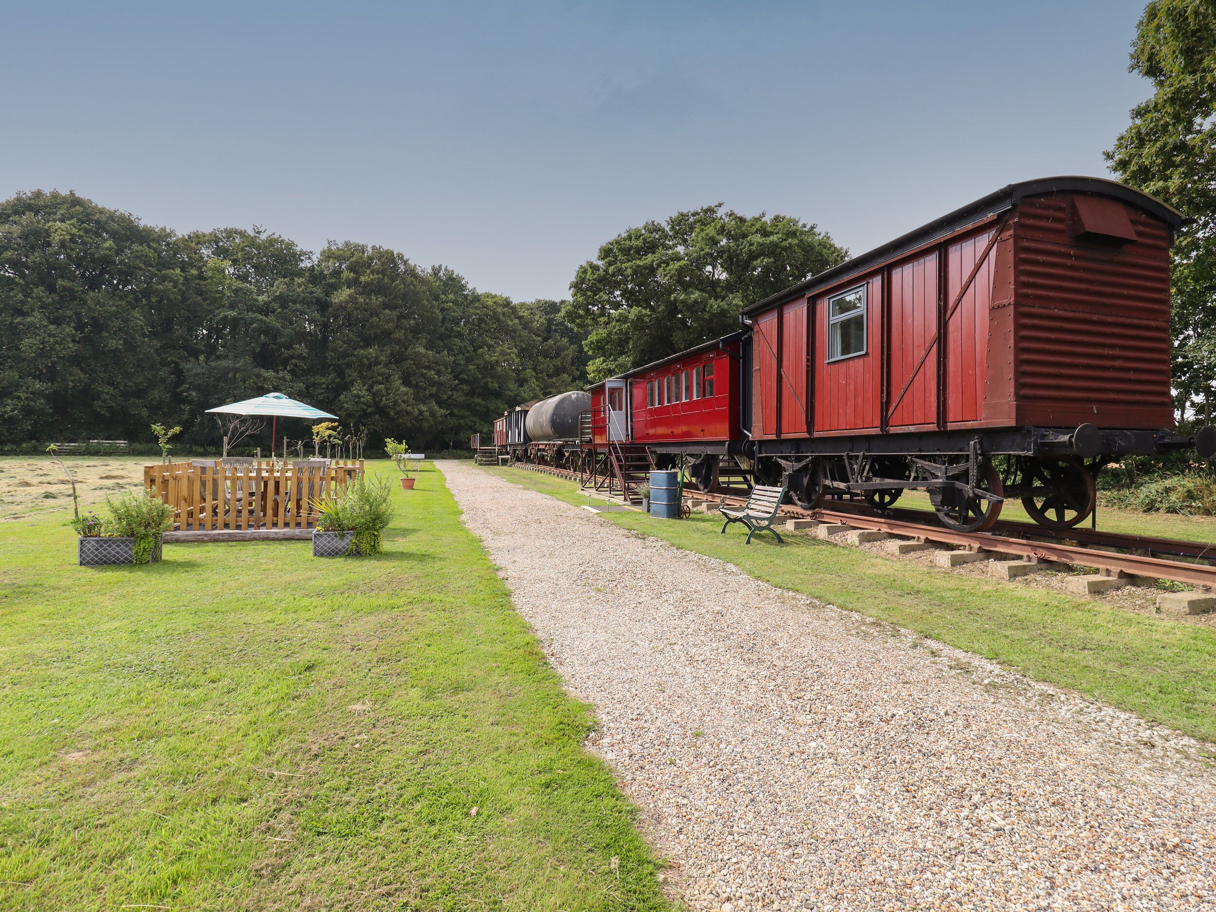 A gravel path leading to a red train car.