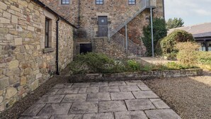 Un edificio de piedra con una escalera que lleva al segundo piso.