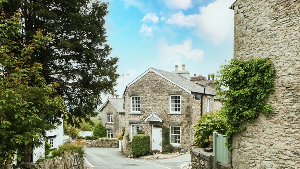 A stone building with a traditional design, featuring a central entrance and multiple windows. - Mount Pleasant Cottage (Grange-over-Sands)