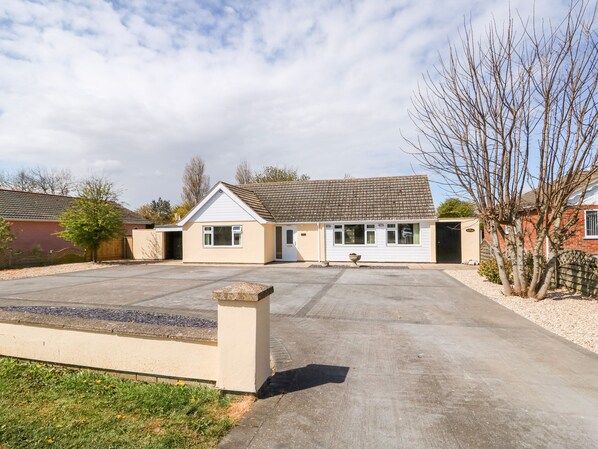 A single-story house with a tiled roof, a driveway, and a small garden area. - The Hemploe (Mablethorpe)