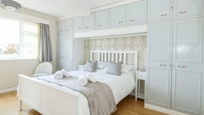 Une chambre à coucher comprenant un lit, une chaise, une table de chevet et une armoire.