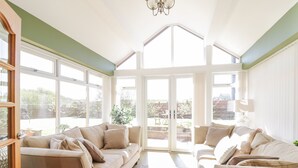 A spacious room with a high ceiling, large windows, and a view of the outdoors.