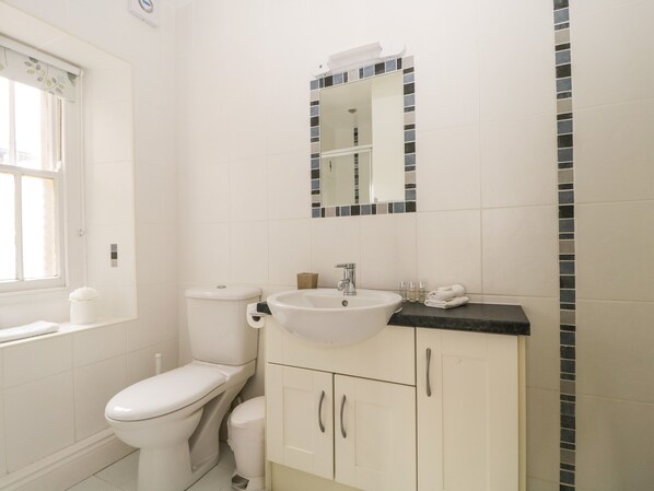 Un baño con inodoro, lavabo y espejo.