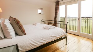 Un dormitorio con una cama, una ventana y vista a un área con césped.