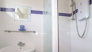 A bathroom with a white sink, a mirror, and a shower with a handheld showerhead. - 224 Atlantic Bays (Padstow)